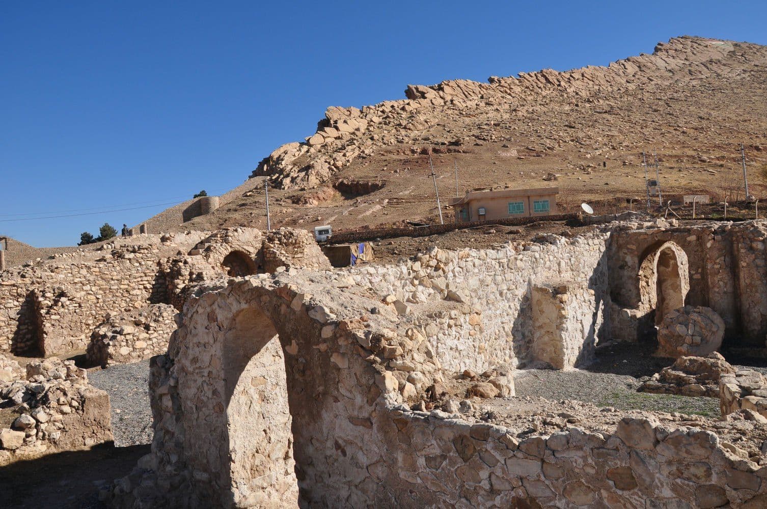 Arched wall of the Bazyan site against the hillside