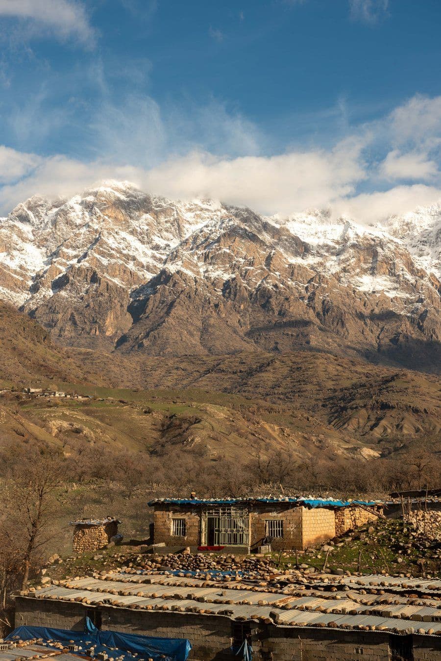 Village houses beneath snow-capped mountains