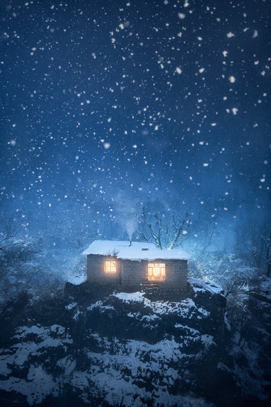 Snowy house glowing at night