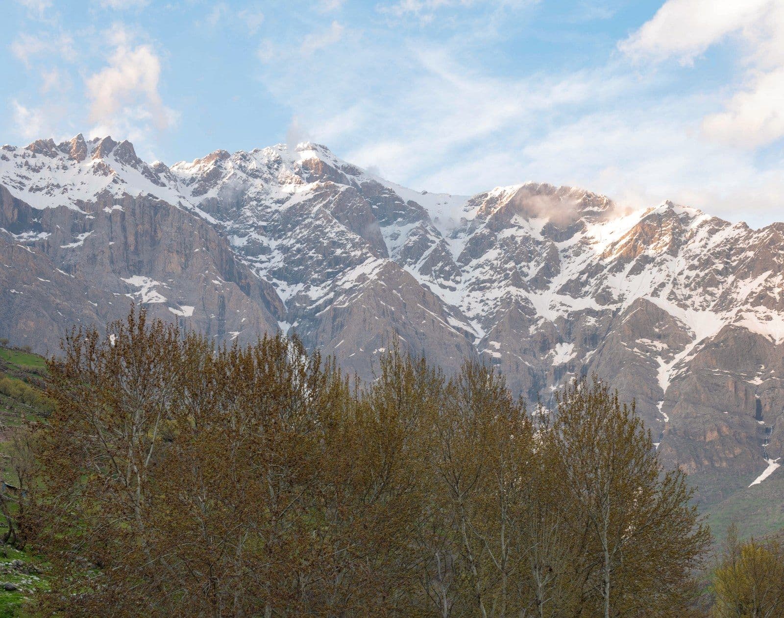 Snow-capped ridge above a wooded river valley in the Kurdistan Region