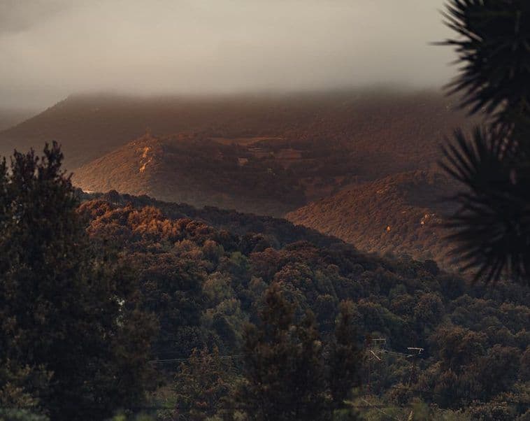 Cloud rolling over a dark ridge at dusk