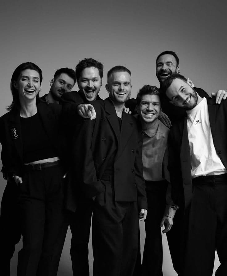 Agency team in black tailoring against a dark backdrop
